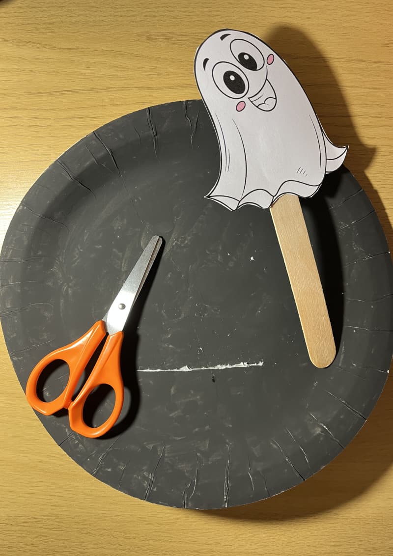 Φαντασματούλης χειροτεχνία φτιαγμένη από λευκό χάρτινο πιάτο και ξυλάκι — Halloween χειροτεχνία