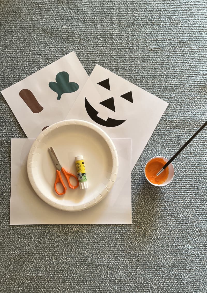 Κολοκύθα Halloween φτιαγμένη από χάρτινο πιάτο βαμμένο πορτοκαλί με χαρακτηριστικά από λωρίδες χαρτιού