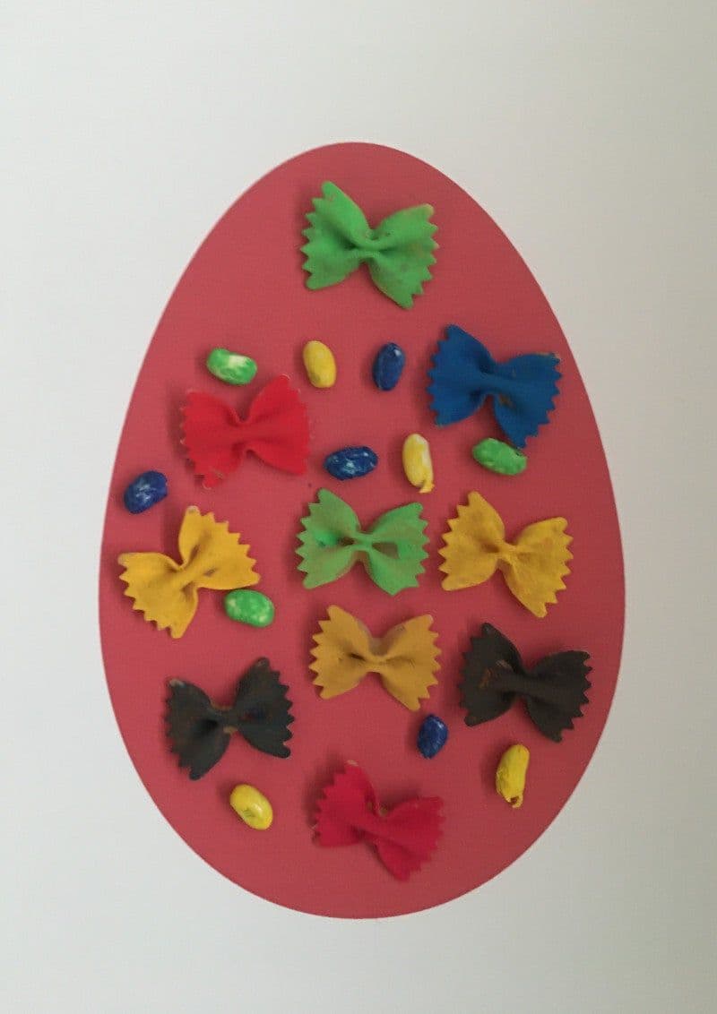 Craft for Easter for kids. Easter egg with colored pasta and beans.