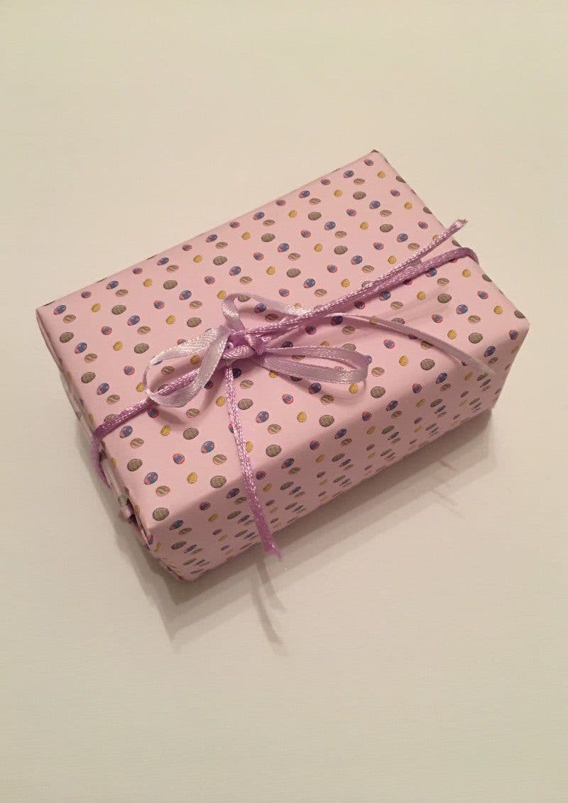 Free printable wrapping paper for Easter with Easter and spring motifs. Wrapped package with Easter wrapping paper.