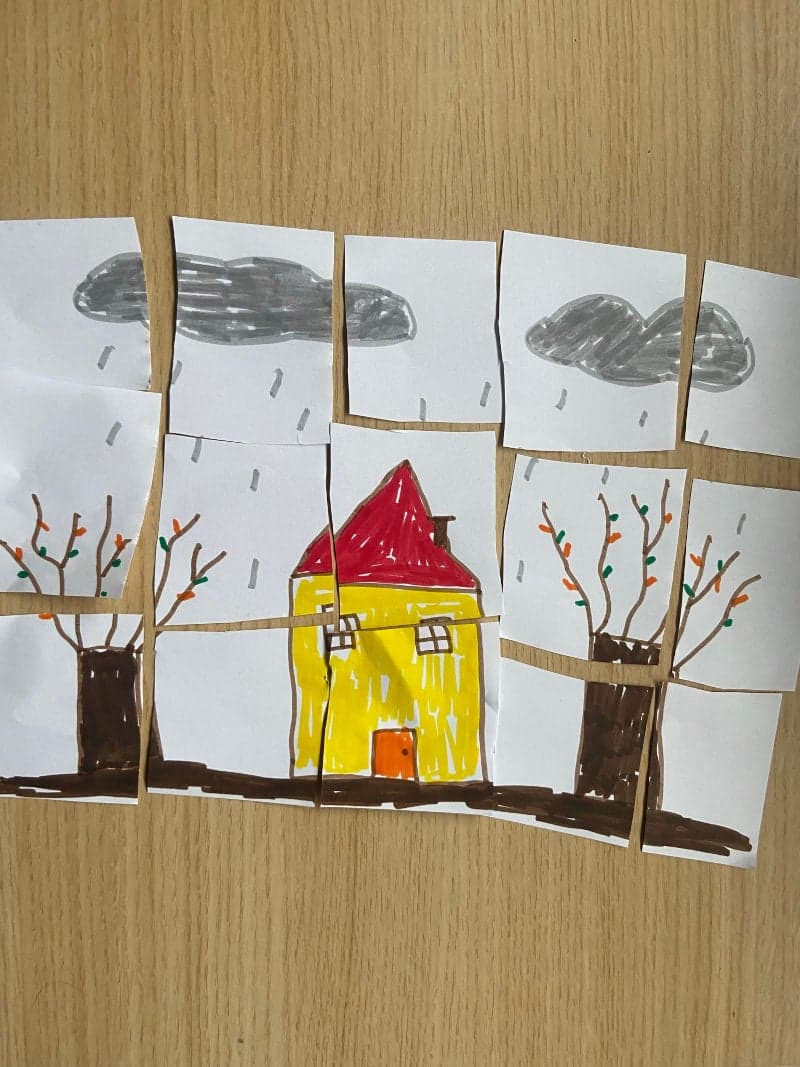 Educational play for preschoolers. Child drawing cut into pieces to create a puzzle.