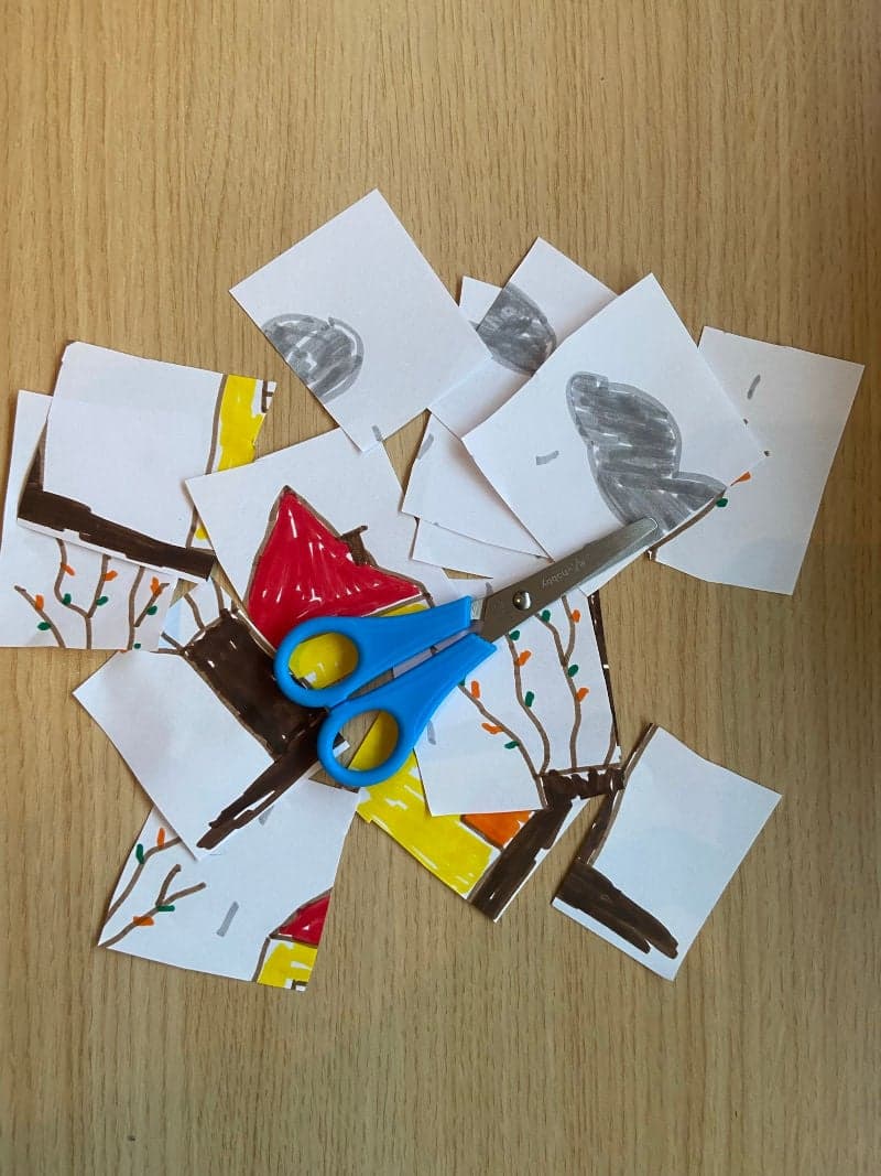Educational play for preschoolers. Child drawing cut into small pieces.